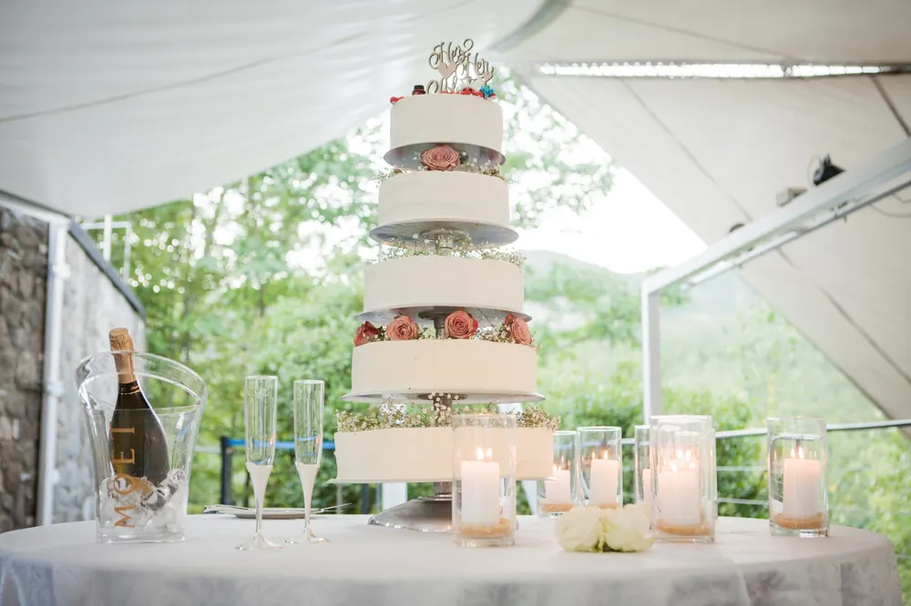 Torta nuziale a più piani con rose e candele