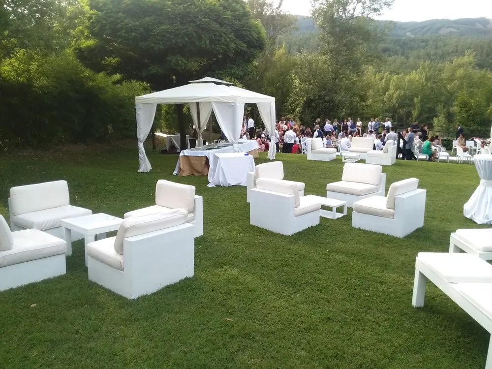 Area lounge esterna con divani bianchi sul prato